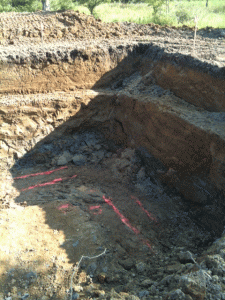 Picture of the hole today.  You can see the blue clay at the bottom corner.  The orange lines are where the footers will go.  The ledged walls will soon be excavated out at an angle for safety and stability.